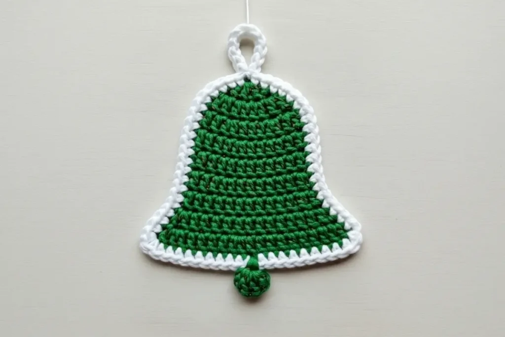 Flat crochet bell ornament pattern – green and white crocheted bell with scalloped edge