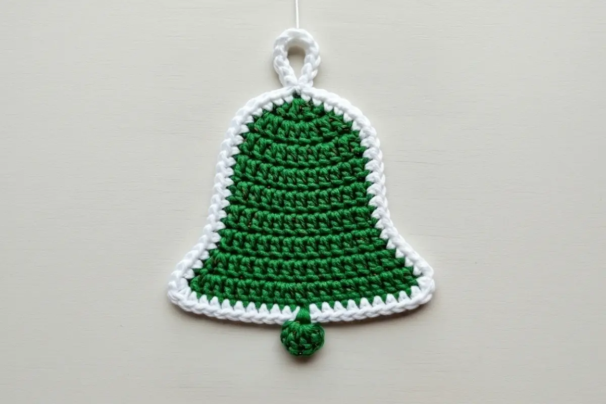 Flat crochet bell ornament pattern – green and white crocheted bell with scalloped edge
