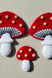 Crochet mushroom applique pattern made with worsted weight yarn in red and cream colors