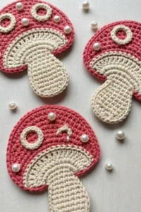 Crochet mushroom applique pattern made with worsted weight yarn in red and cream colors