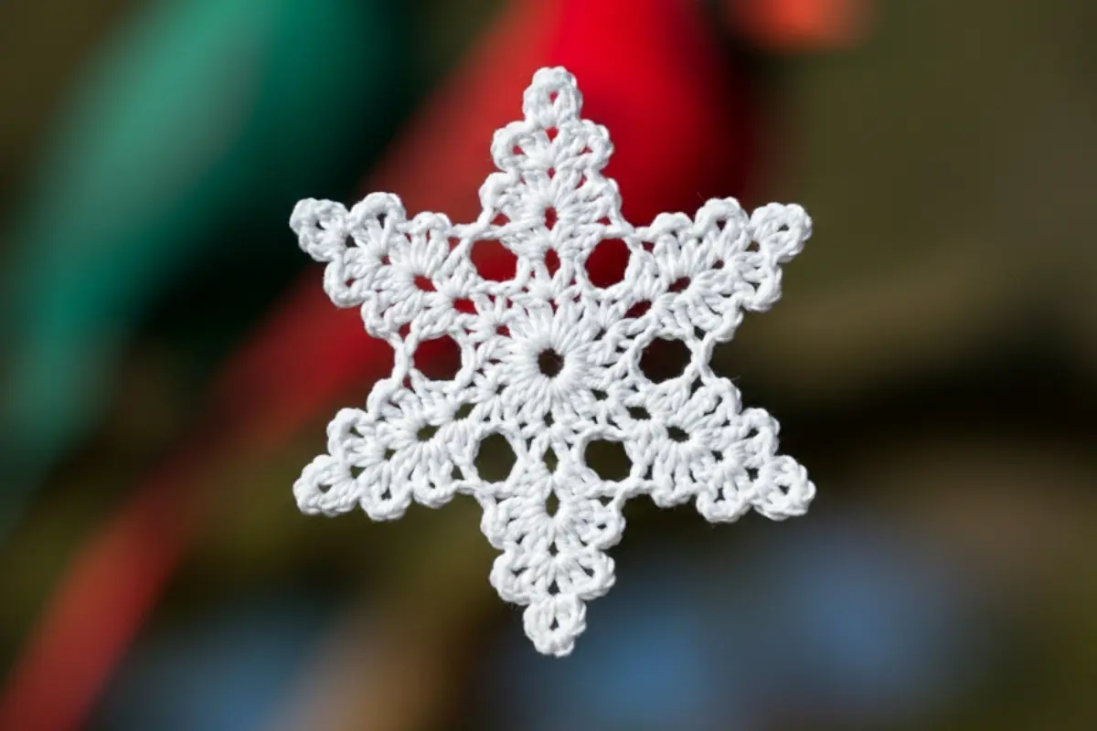 Handmade crochet snowflake pattern in white cotton thread, easy winter decoration